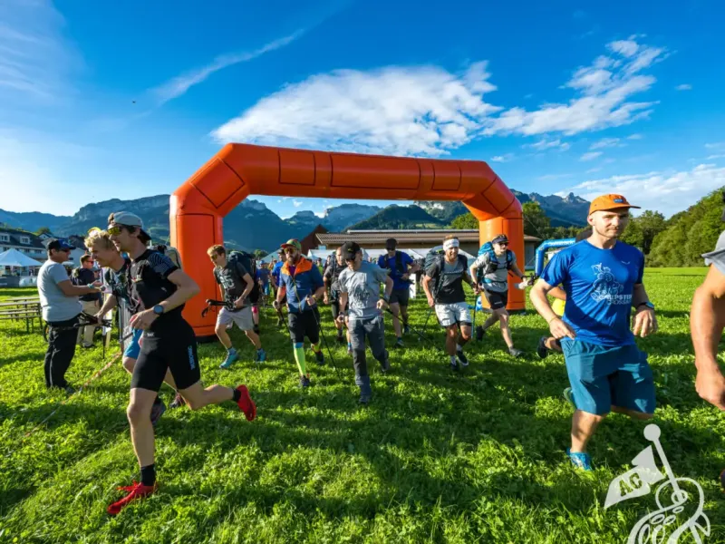 Start des Alpstein Crossing unter einem orangen Startbogen.