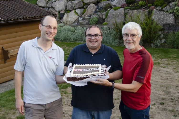 Das Fixcontrol-Kernteam: Beat, Gion-Andri und Markus halten eine Torte mit Fixcontrol-Logo.